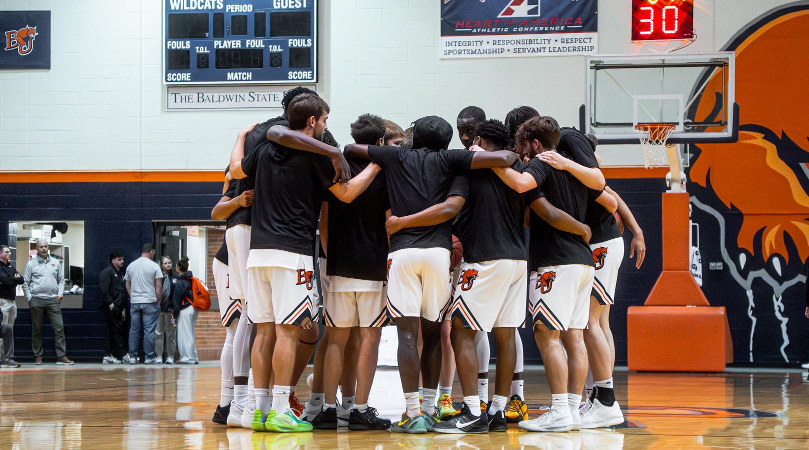 Baker men's basketball team huddle at home against Benedictine