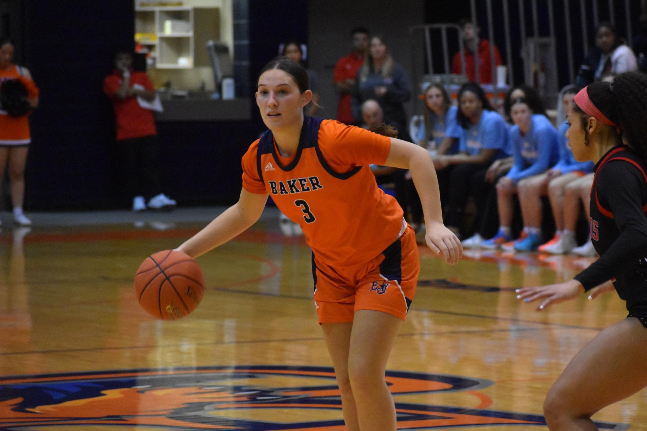 Kennedy Bryan dribbling against Friends defender at home basketball game.